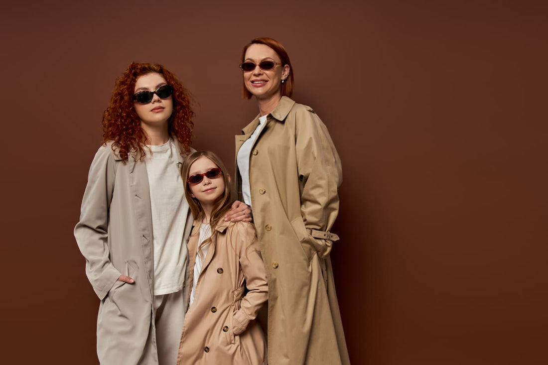 featured image Fall Family Picture Outfit Ideas, family portrait of female generations in sunglasses and coats on brown background, hands in pockets