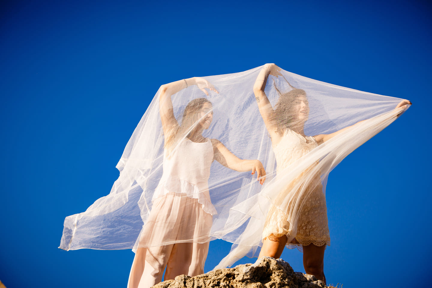 Beach Wedding Attire image, Young women with textile on stone