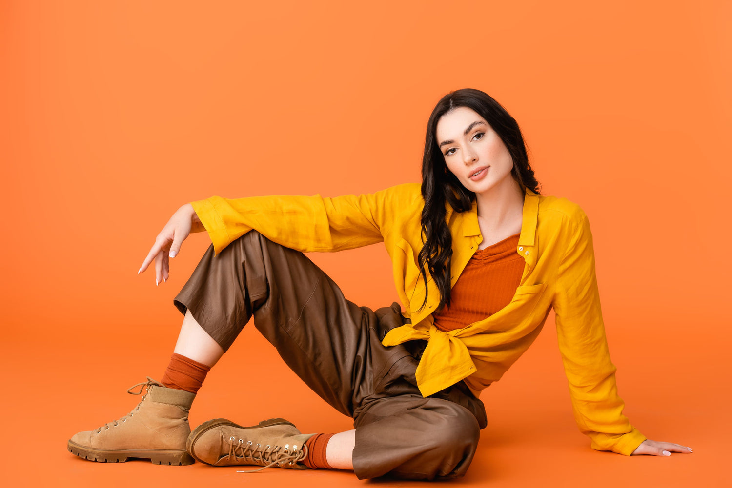 Boot Trends Fall image, fashionable young woman in autumn outfit and boots looking at camera while sitting on orange