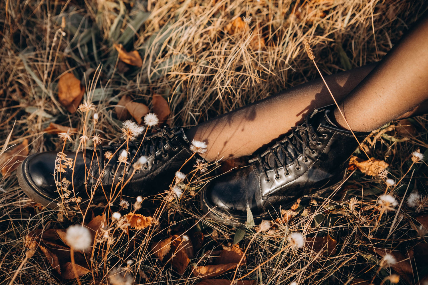 Fall Shoe Trends image, young curly girl in an orange sweater against the backdrop of autumn nature