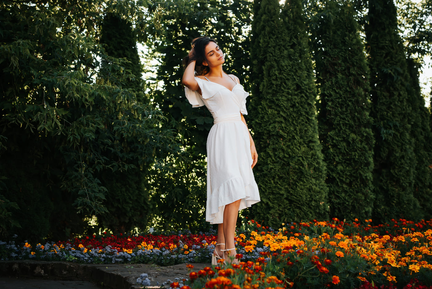 what to wear to a wedding for garden wedding image, Elegant young brunette woman posing with closed eyes near flower bed, beautiful lady with dark skin